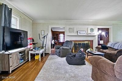 402 S Woodlawn Ave, Lima, OH 45805 - living room with wood finished floors, ornamental molding, healthy amount of natural light, and a glass covered fireplace