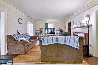 402 S Woodlawn Ave, Lima, OH 45805 - living area with wood finished floors, crown molding, and a fireplace