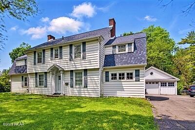 402 S Woodlawn Ave, Lima, OH 45805 - colonial home featuring a detached garage, a chimney, and a front yard