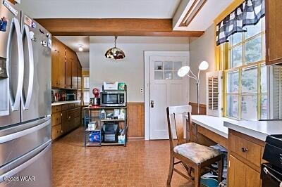 402 S Woodlawn Ave, Lima, OH 45805 - kitchen featuring stainless steel appliances, brown cabinets, light countertops, wainscoting, and a desk