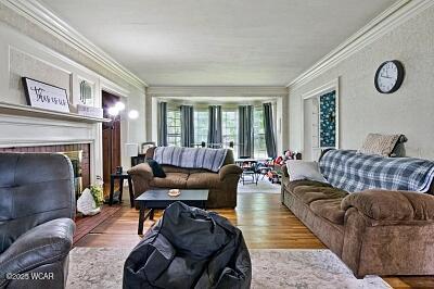 402 S Woodlawn Ave, Lima, OH 45805 - living room with crown molding, wood finished floors, and a fireplace