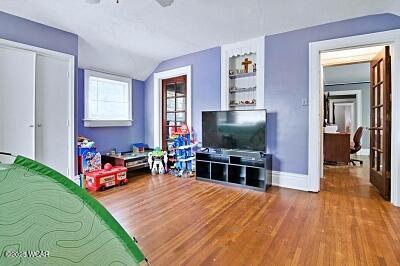 402 S Woodlawn Ave, Lima, OH 45805 - recreation room with wood finished floors, lofted ceiling, baseboards, and ceiling fan