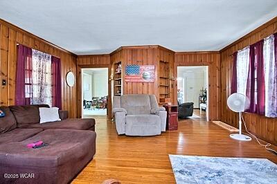 402 S Woodlawn Ave, Lima, OH 45805 - living area with wooden walls, healthy amount of natural light, light wood finished floors, and crown molding