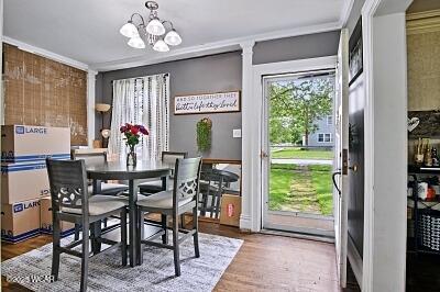 402 S Woodlawn Ave, Lima, OH 45805 - dining area with crown molding, a chandelier, and wood finished floors