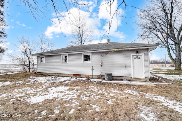 snow covered rear of property with central AC unit