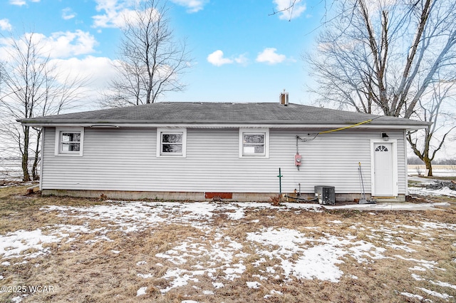 snow covered house featuring central air condition unit