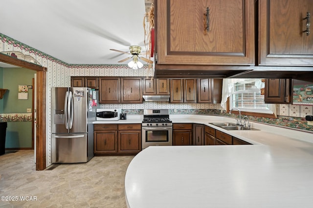10815 Holdgreve Rd, Delphos, OH 45833 - kitchen with stainless steel appliances, wallpapered walls, light countertops, a ceiling fan, and under cabinet range hood