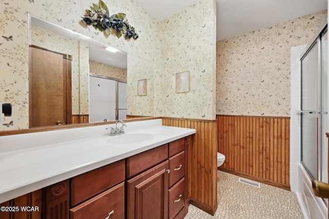 10815 Holdgreve Rd, Delphos, OH 45833 - bathroom featuring a wainscoted wall, wallpapered walls, vanity, wooden walls, and shower / bath combination with glass door