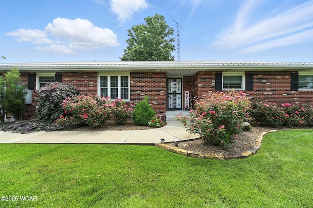 10815 Holdgreve Rd, Delphos, OH 45833 - ranch-style house with a front yard, brick siding, and a metal roof