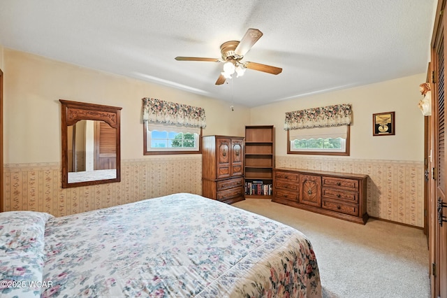 10815 Holdgreve Rd, Delphos, OH 45833 - carpeted bedroom featuring wainscoting, wallpapered walls, a textured ceiling, and a ceiling fan