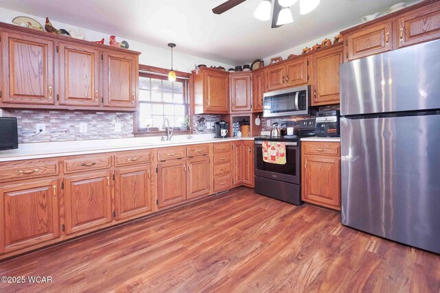 14351 Rd 19, Fort Jennings, OH 45844 - kitchen with stainless steel appliances, a sink, light countertops, brown cabinets, and tasteful backsplash