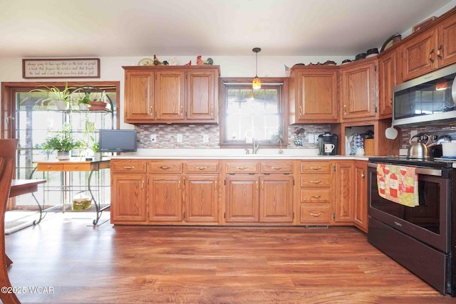 14351 Rd 19, Fort Jennings, OH 45844 - kitchen featuring appliances with stainless steel finishes, light countertops, light wood-type flooring, and tasteful backsplash