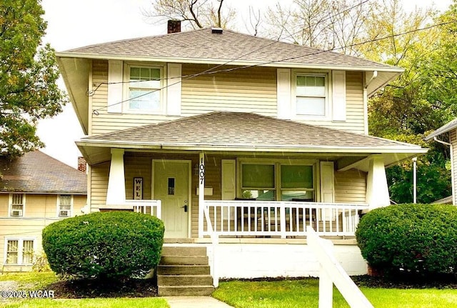 view of front of property with a chimney, a porch, and a shingled roof