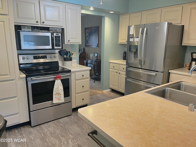 3031 Yoakam Rd, Lima, OH 45806 - kitchen with appliances with stainless steel finishes, light countertops, and white cabinetry