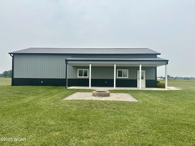 1640 Olt Rd, Columbus Grove, OH 45830 - back of house with an outdoor fire pit, a lawn, a patio area, and a metal roof