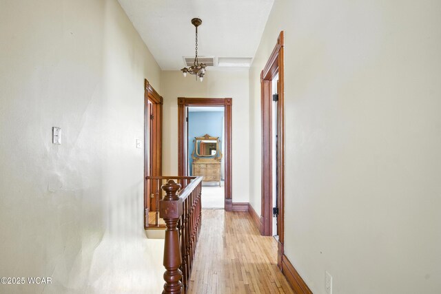 302 N Market St, Van Wert, OH 45891 - corridor with light wood-style flooring, an upstairs landing, and a chandelier