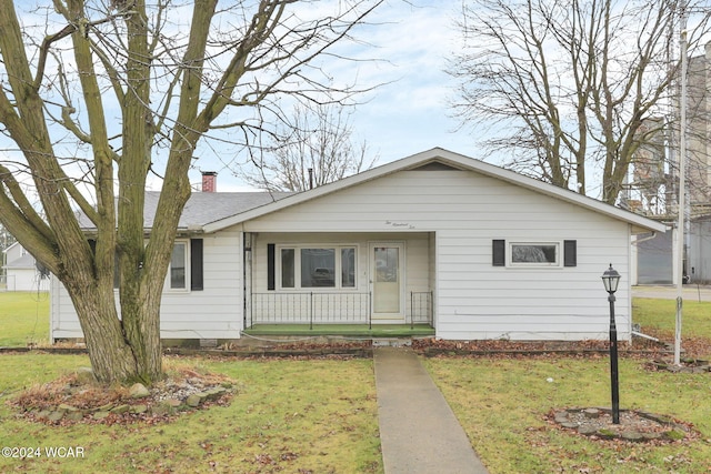 view of front of home with a front yard and covered porch