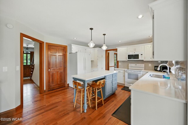 4860 Wenatchi Trl, Lima, OH 45805 - kitchen featuring white appliances, white cabinets, wood finished floors, backsplash, and light countertops