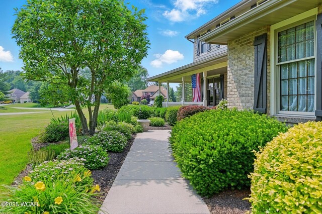 4860 Wenatchi Trl, Lima, OH 45805 - property entrance with a lawn, a porch, and brick siding