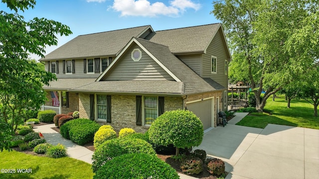 4860 Wenatchi Trl, Lima, OH 45805 - traditional-style home with concrete driveway, roof with shingles, a front yard, an attached garage, and brick siding