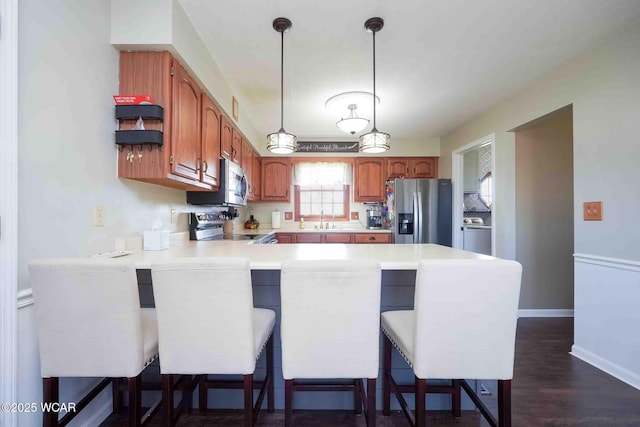 16070 Rd S, Columbus Grove, OH 45830 - kitchen with stainless steel appliances, a peninsula, a sink, light countertops, and decorative light fixtures