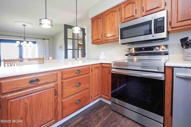 16070 Rd S, Columbus Grove, OH 45830 - kitchen with appliances with stainless steel finishes, dark wood-type flooring, light countertops, brown cabinets, and decorative light fixtures