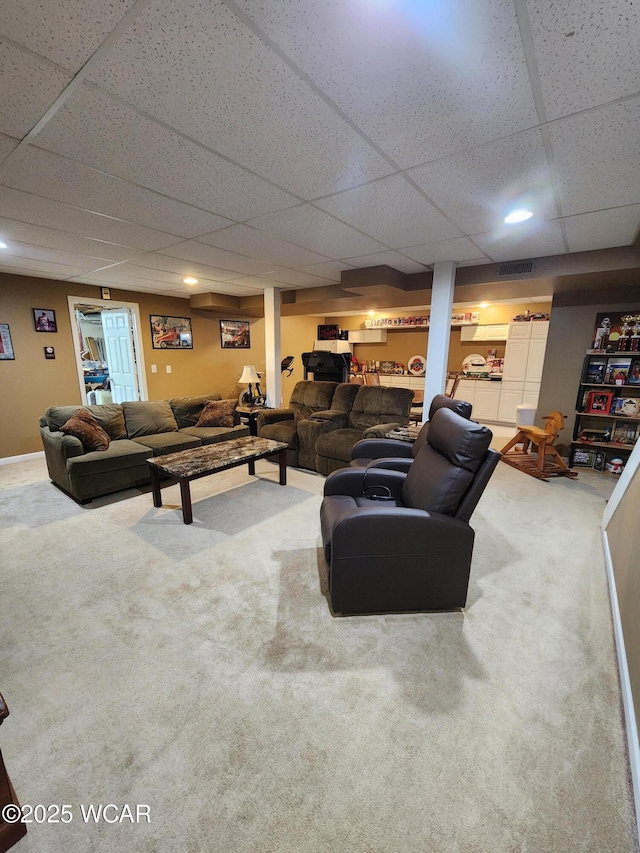 carpeted living area featuring recessed lighting, visible vents, and a drop ceiling