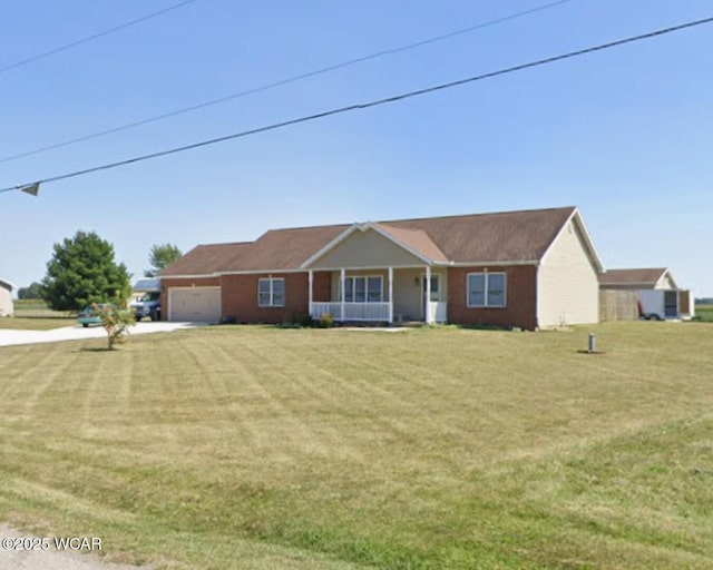 view of front of home with covered porch, an attached garage, driveway, and a front yard