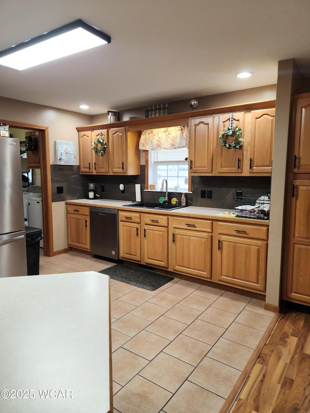 kitchen with recessed lighting, freestanding refrigerator, a sink, dishwasher, and backsplash