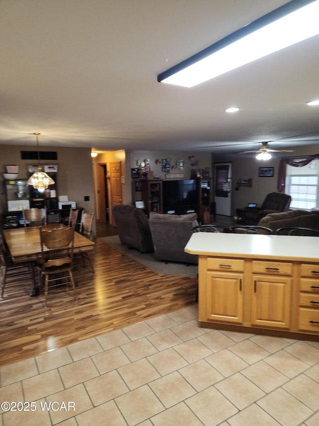 kitchen featuring light tile patterned floors, open floor plan, light countertops, and ceiling fan