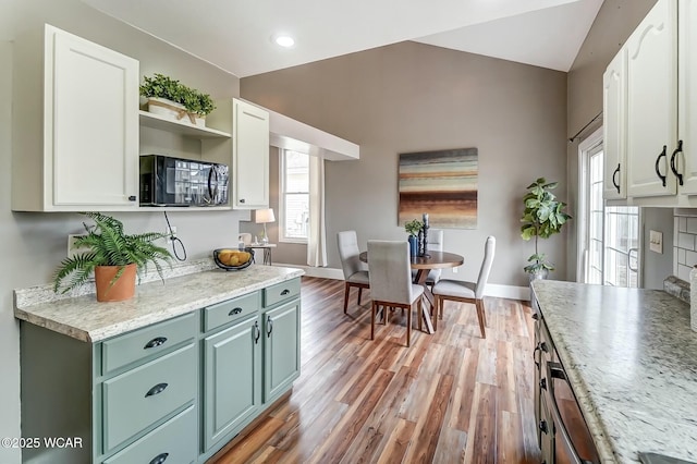 kitchen featuring baseboards, light wood-style flooring, and white cabinets