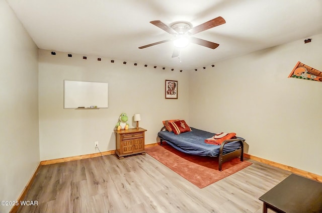 bedroom with a ceiling fan, baseboards, and wood finished floors