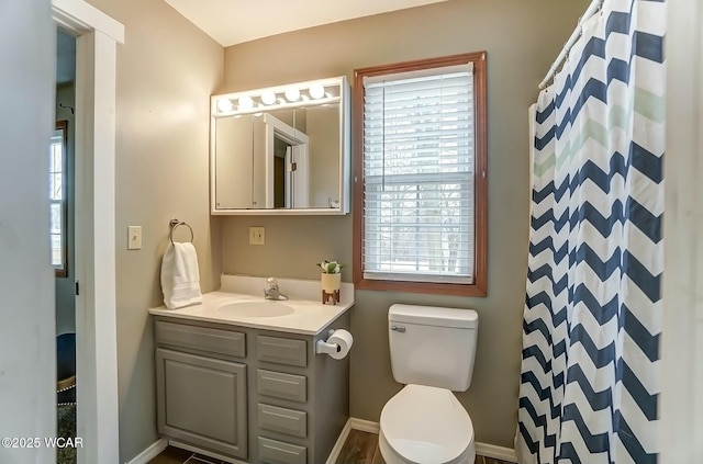 full bathroom featuring toilet, curtained shower, baseboards, and vanity