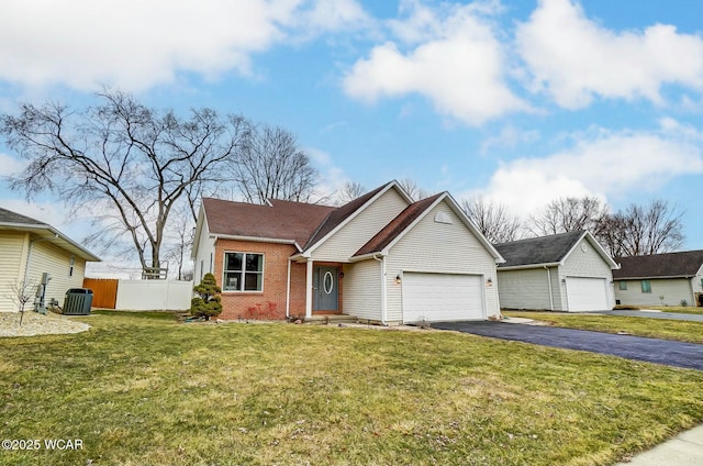 view of front facade featuring aphalt driveway, brick siding, a front yard, fence, and cooling unit