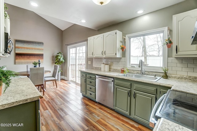 kitchen featuring electric range, stainless steel dishwasher, vaulted ceiling, a sink, and green cabinetry