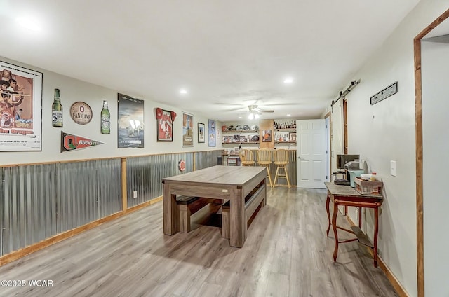 recreation room with a dry bar, light wood finished floors, a wainscoted wall, ceiling fan, and recessed lighting