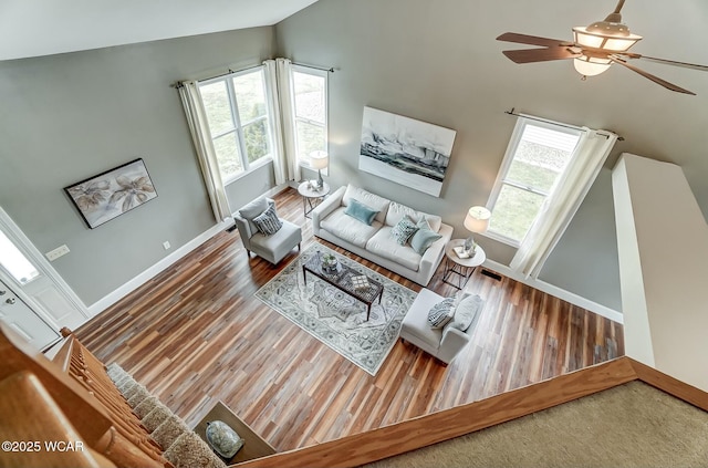 living area with plenty of natural light, baseboards, and wood finished floors