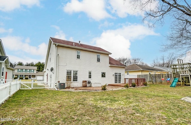 back of property featuring a deck, a yard, a playground, and a fenced backyard