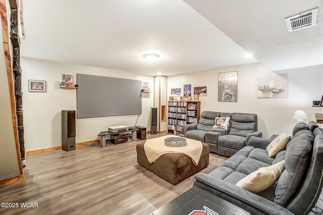 living room with light wood-type flooring, baseboards, and visible vents