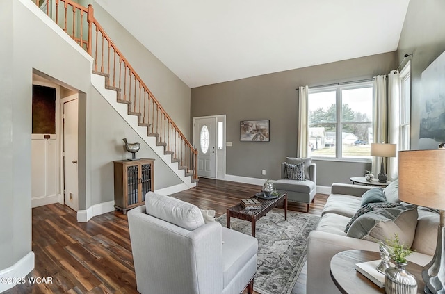 living room featuring dark wood-type flooring, stairway, and baseboards