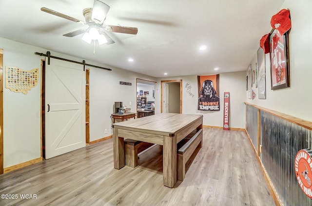 rec room featuring a ceiling fan, light wood-type flooring, recessed lighting, and a barn door