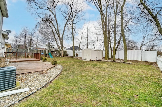 view of yard featuring a shed, an outdoor structure, central AC, and a fenced backyard