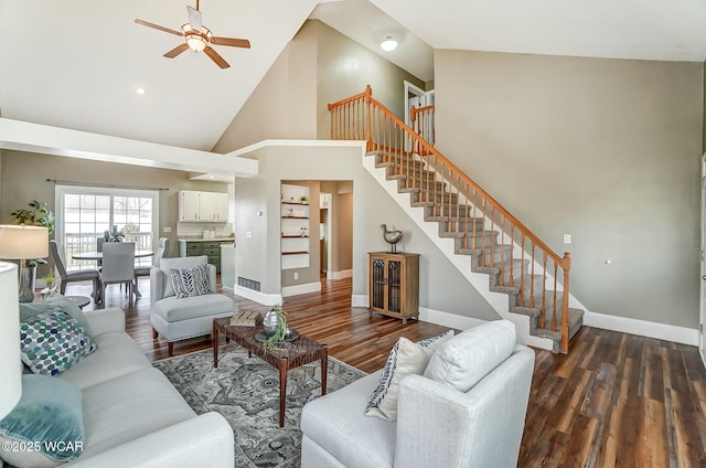 living area with baseboards, dark wood finished floors, ceiling fan, stairs, and high vaulted ceiling