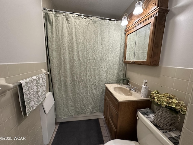 bathroom with tile patterned floors, toilet, tile walls, and vanity