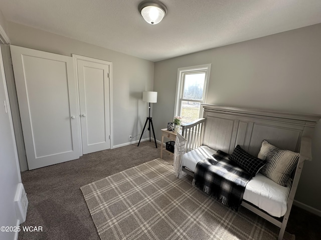 interior space with baseboards, a textured ceiling, and dark carpet