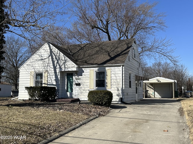 view of front of home featuring driveway, an outdoor structure, and a garage