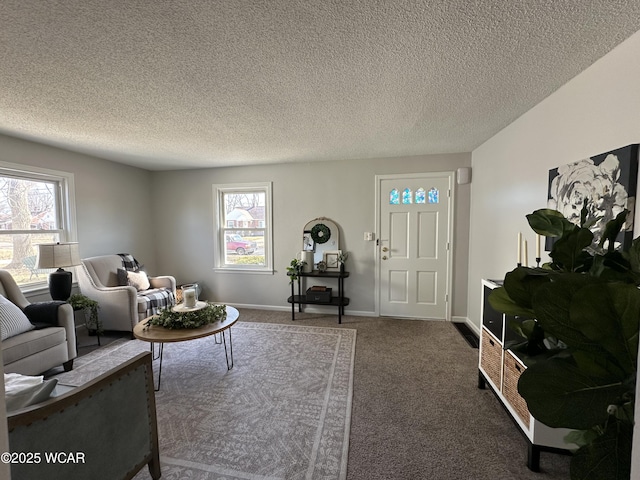 carpeted living area featuring baseboards and a textured ceiling