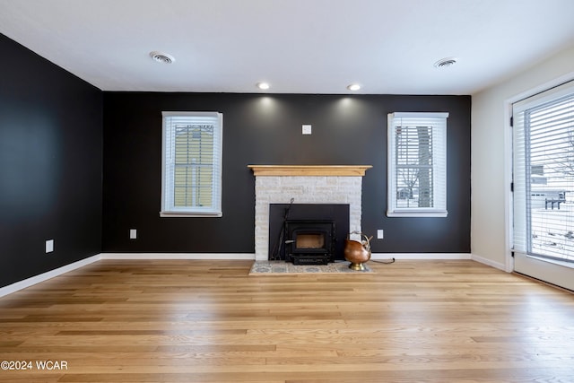 unfurnished living room with baseboards, visible vents, and wood finished floors