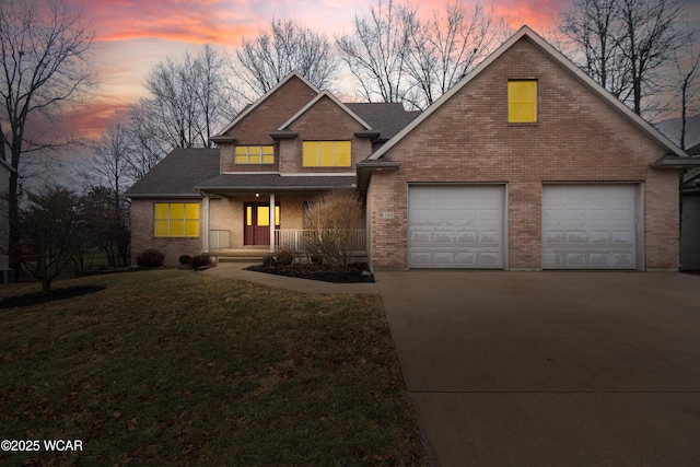 view of front of property featuring a garage, covered porch, and a lawn