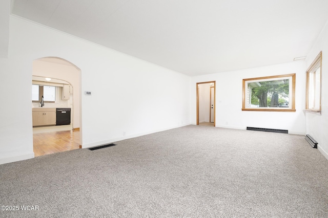 247 W State St, West Mansfield, OH 43358 - carpeted spare room featuring arched walkways, a baseboard heating unit, crown molding, and baseboards